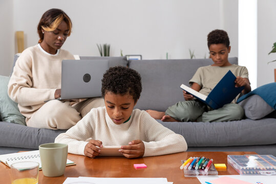 Single mother and two sons spending time in living room