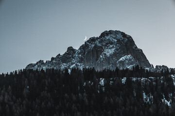 snow covered mountains crescent moon behind