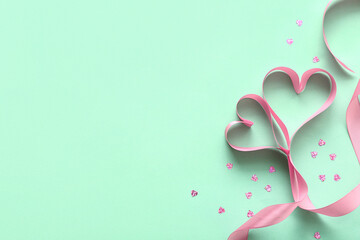 Hearts made of ribbon and sequins on green background. Valentine's Day celebration