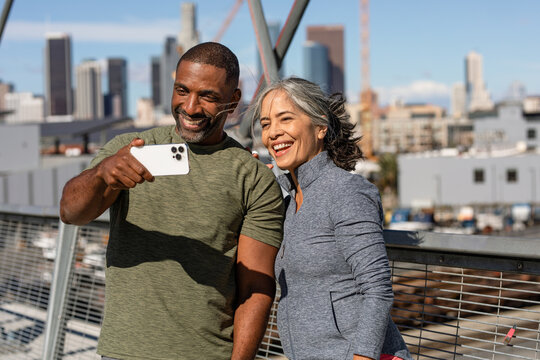 Two Adults Take A Selfie On A Bridge During Morning Exercise 