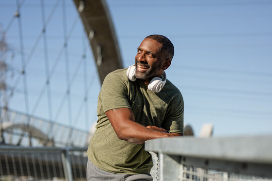 Fit Man Takes A Breather From His Jogging While Wearing Headphones