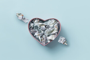 Heart box with dollars pierced with money arrow.