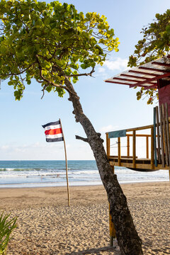 Costa Rica flag on bamboo flagpole remote beach lifeguard stand 