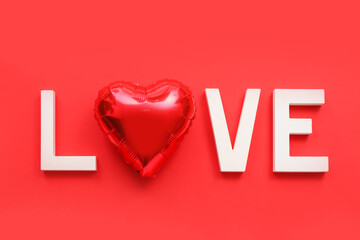 Word LOVE made of white letters and balloon on red background. Valentine's Day celebration