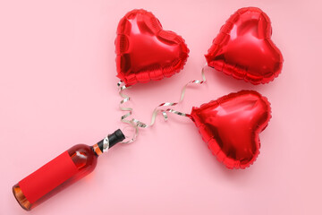 Bottle of wine with heart shaped balloons on pink background. Valentine's Day celebration