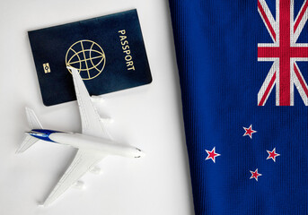 Flag of New Zealandn with passport and toy airplane. Flight travel concept
