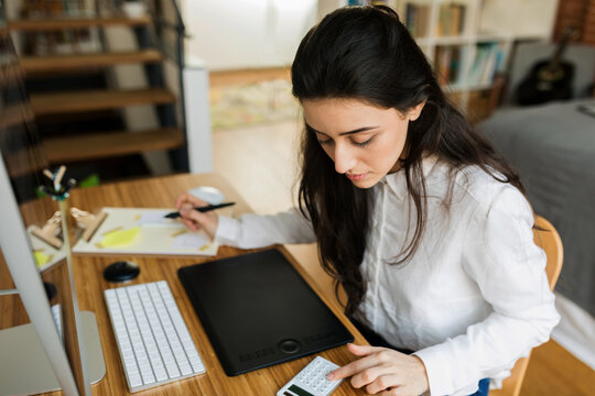 Financial businesswoman using calculator at desk