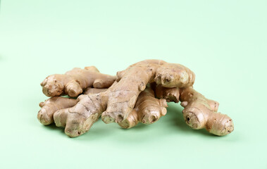 Fresh ginger roots on green background