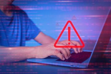 Man used computer for working. Virtual security warning system hacked alert on laptop screen. Cybersecurity vulnerability on internet, virus, data breach, malicious connection. Selective focus
