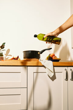 Pouring olive oil into a cooking pot 