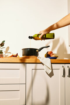 Pouring olive oil into a cooking pot 