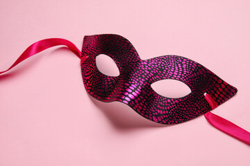 Beautiful carnival mask for Mardi Gras celebration on pink background