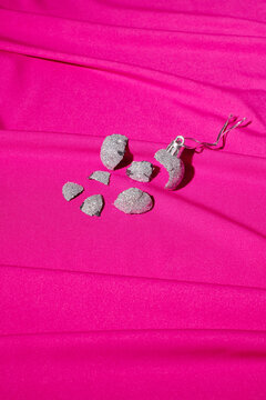 Broken christmas ball on pink background
