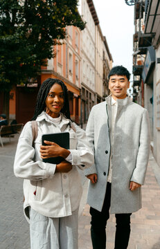 work friends in stylish Autumn wear in city street looking at camera