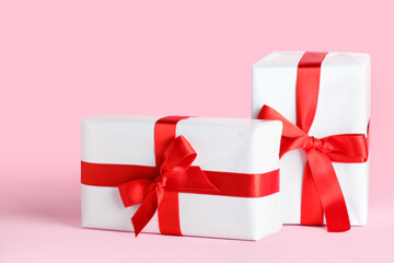 Gift boxes with beautiful bows on pink background. Valentine's Day celebration