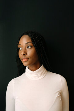 Portrait of beautiful woman with braided hair over black background