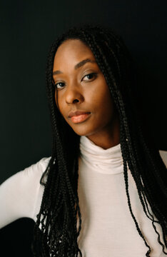 Portrait of beautiful woman with braided hair over black background