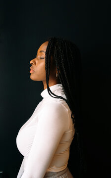 Profile of beautiful woman with cornrows over black background