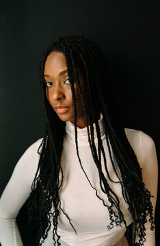 Portrait of beautiful woman with braided hair over black background