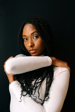 Portrait of beautiful woman with braided hair over black background