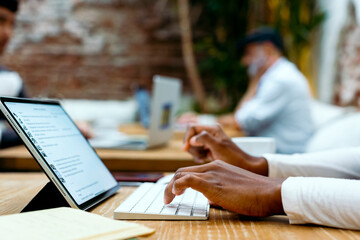 Anonymous woman hands typing on wireless keyboard working on tablet