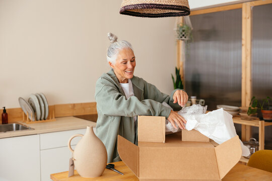Mature woman unpacking order in kitchen