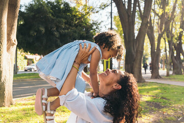 Cheerful Mom Holding Up Her Daughter