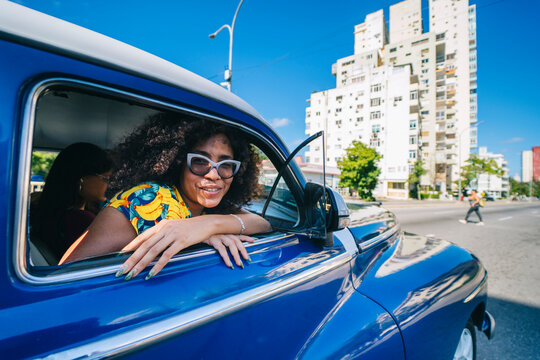 Afro girl leaning out of a car window