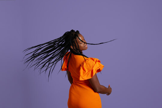 Glad woman shaking braided hair
