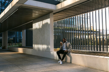 A man is sitting outdoors in downtown