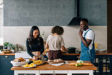Diverse friends preparing healthy food in kitchen