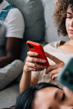 Close up of women using phones while resting in living room