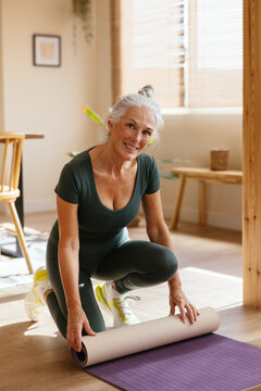 Senior woman doing fitness on floor at home