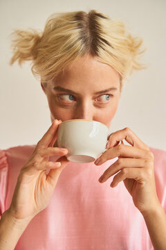 Blond female sipping coffee from cup