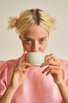 Blond female sipping tea from cup