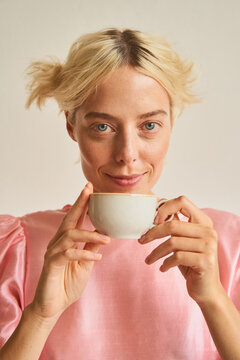 Happy blond woman enjoying tea