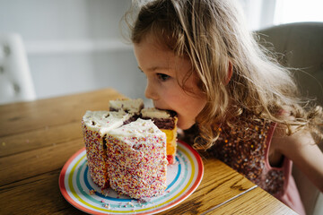 Little girl eating colorful cake