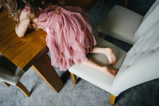 Little girl in pink dress on a chair