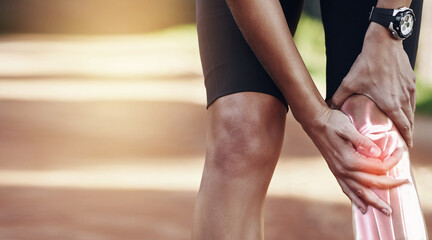 Hands, knee and injury with a sports man holding his joint in pain after suffering an accident while running outdoor. Fitness, exercise or training and a male athlete struggling with an injured leg