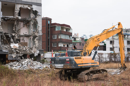 Smashed building and huge excavator