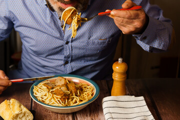 bearded man eating meatballs with spaghetti