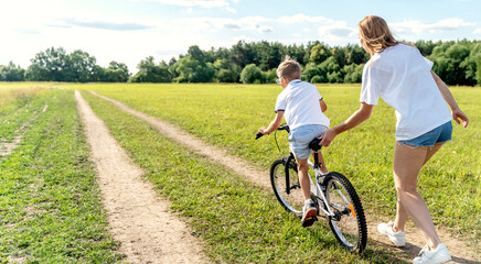 mom teaches her son to ride a bike