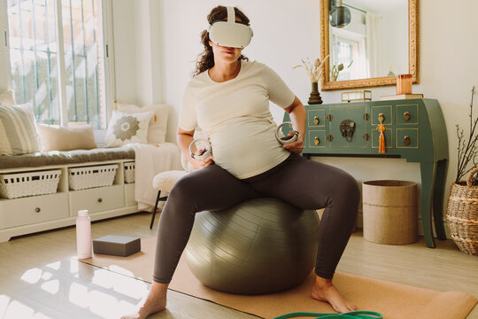A woman using a VR headset for doing pre-labor exercises