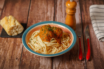 plate of meatballs with spaghetti with cutlery and bread