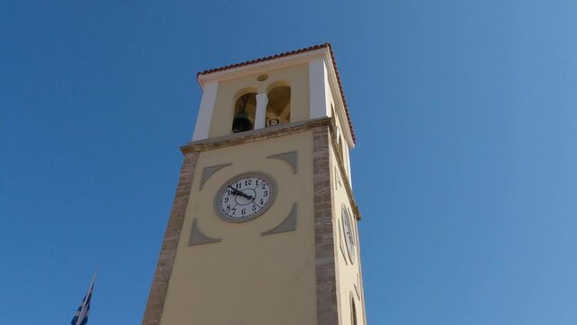 Saint charalambos church, an old historic yellow and brown building with a white clock in Preveza, Greece.