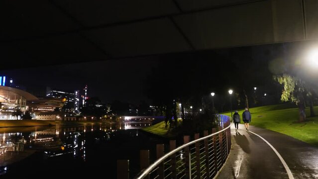 Adelaide Convention Centre in Dark Early Morning with Couple walking on River Torrens 