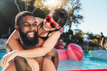 Pool party, love and couple piggyback, having fun or bonding. Swimming, romance diversity and happy...