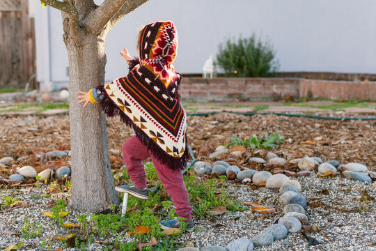 Boy with poncho enjoying at garden