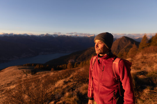 Hiker in the mountains looking at sunset - Powered by Adobe