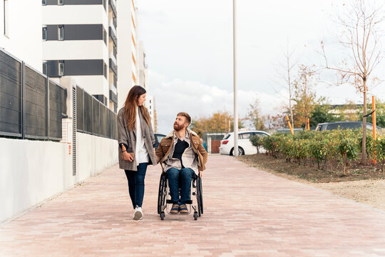 Happy disabled man in Wheelchair Talking with Girlfriend